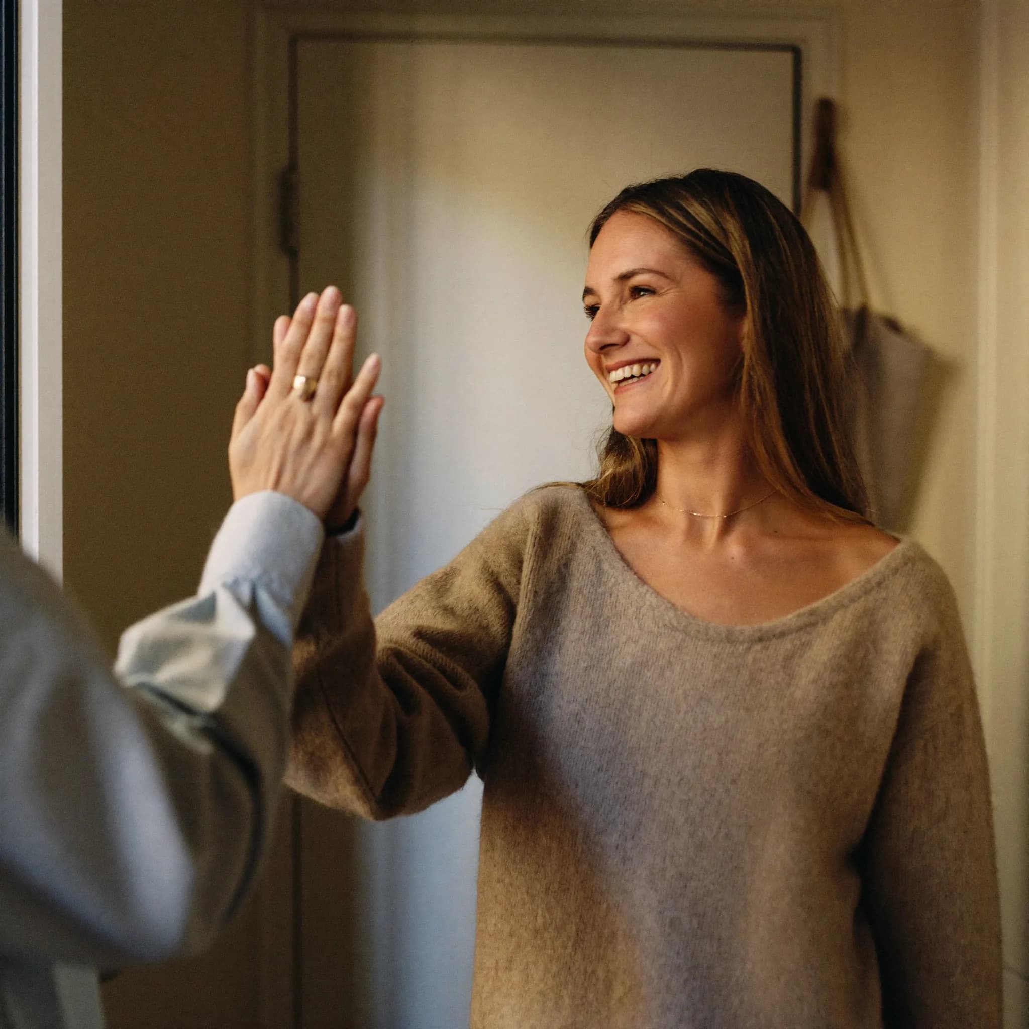 A volunteer welcoming a woman into a community session