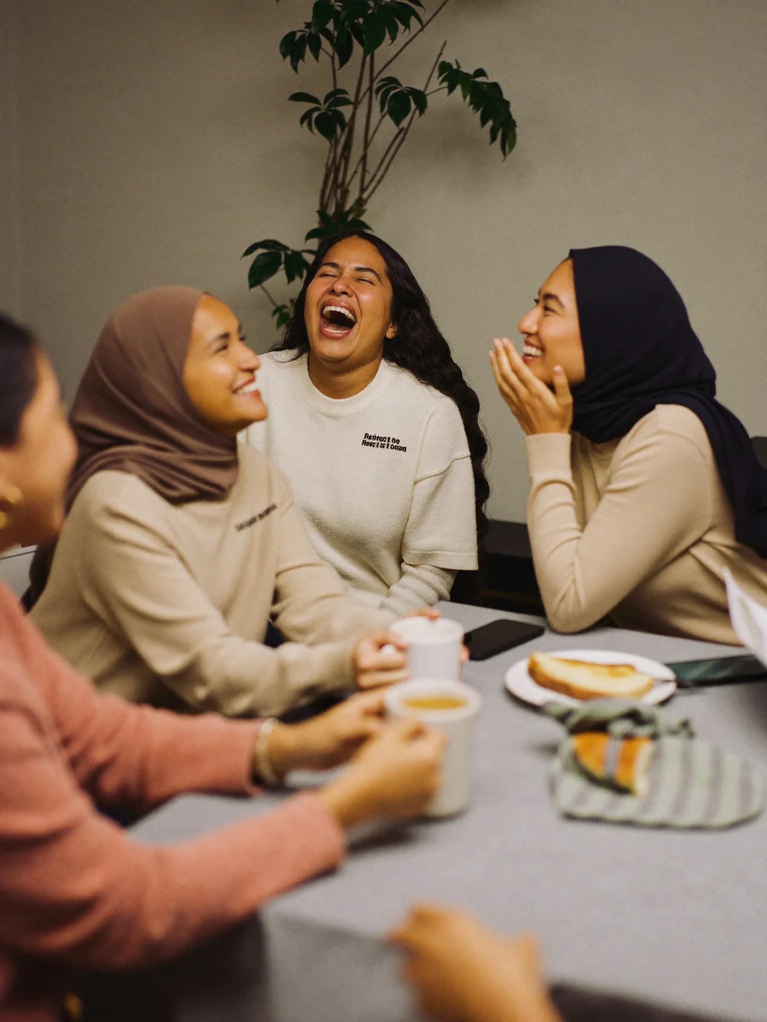 Women learning together around a table at a coffee morning