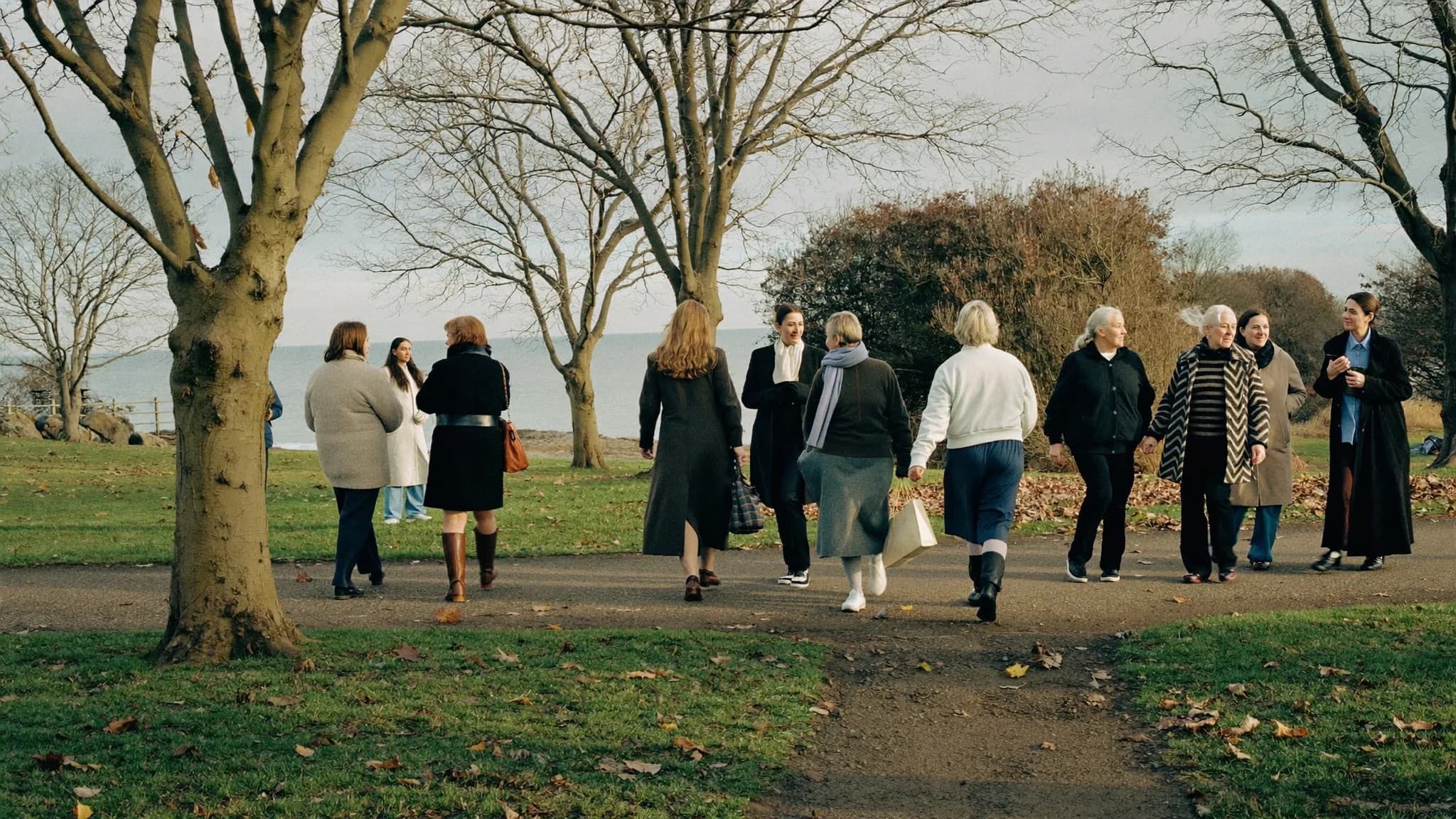 A group of women walking together through a park on an autumn morning