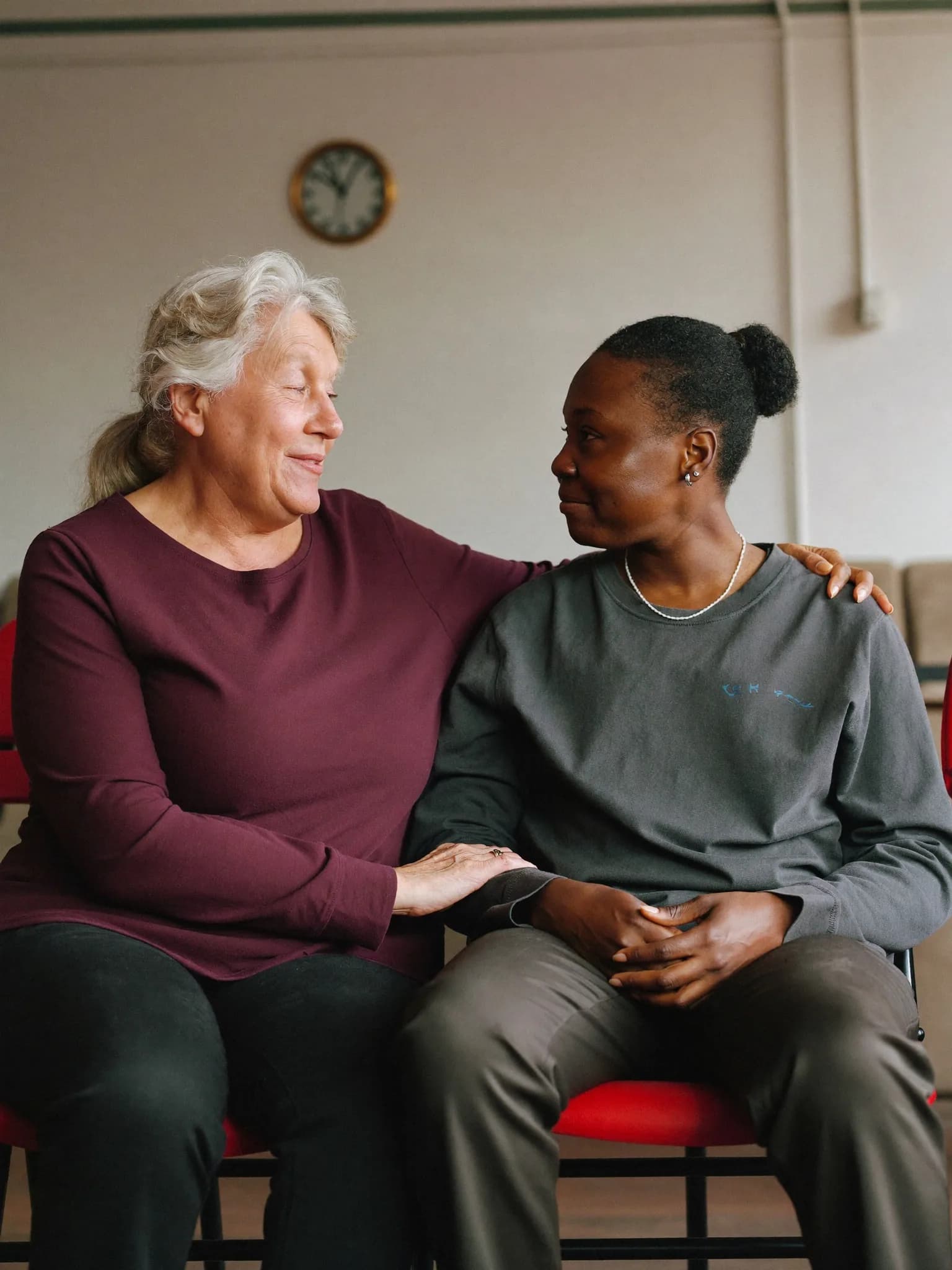 Two women sitting together, one comforting the other